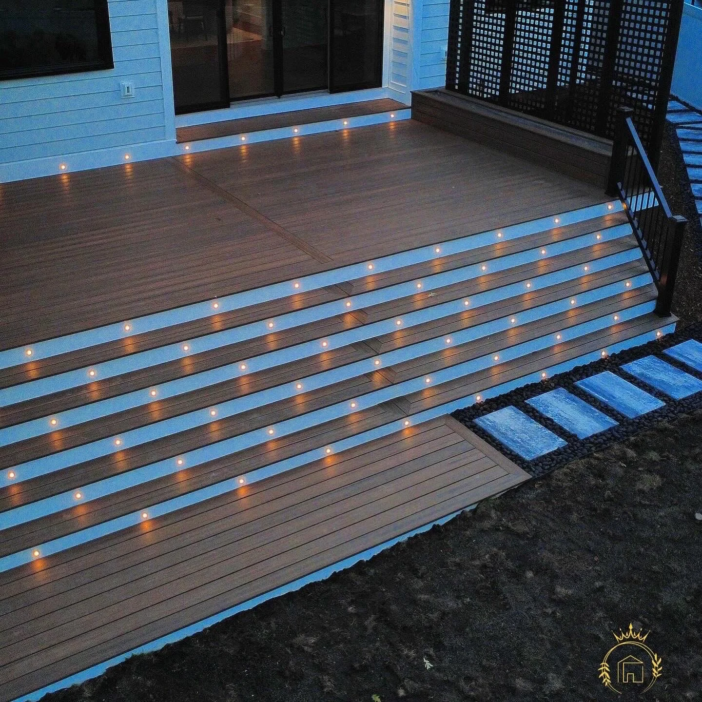 The completed deck and broad illuminated staircase at dusk.