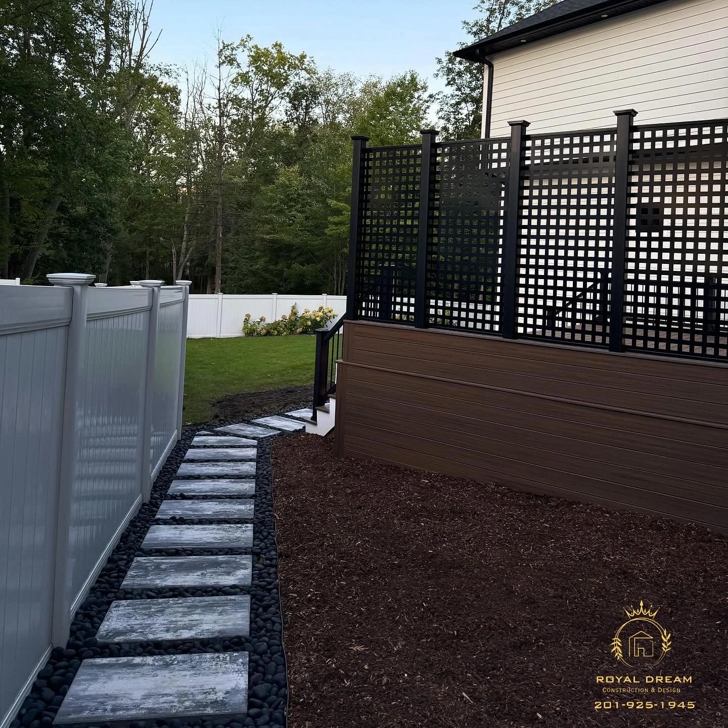 Deck skirting and a privacy screen alongside a stepping-stone garden path.