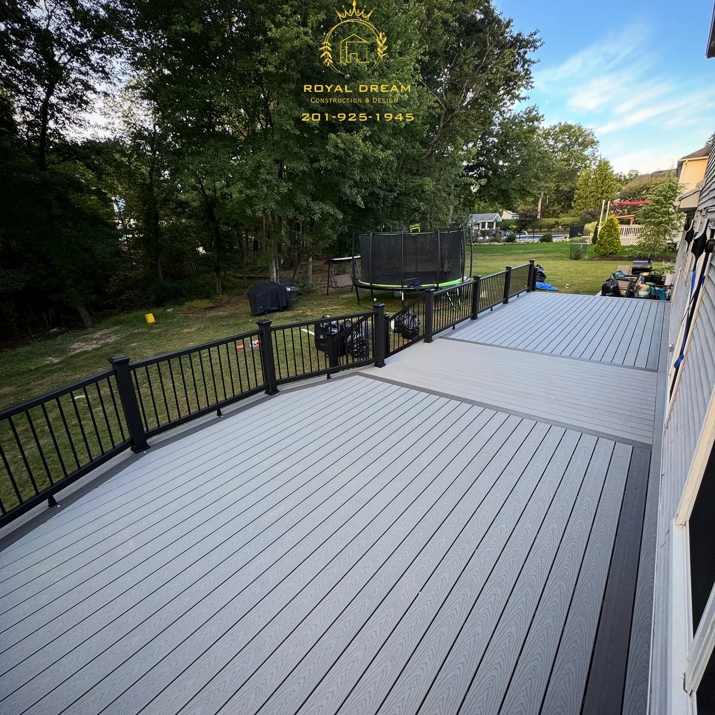 An open deck surface with a contrasting border and black perimeter railing.