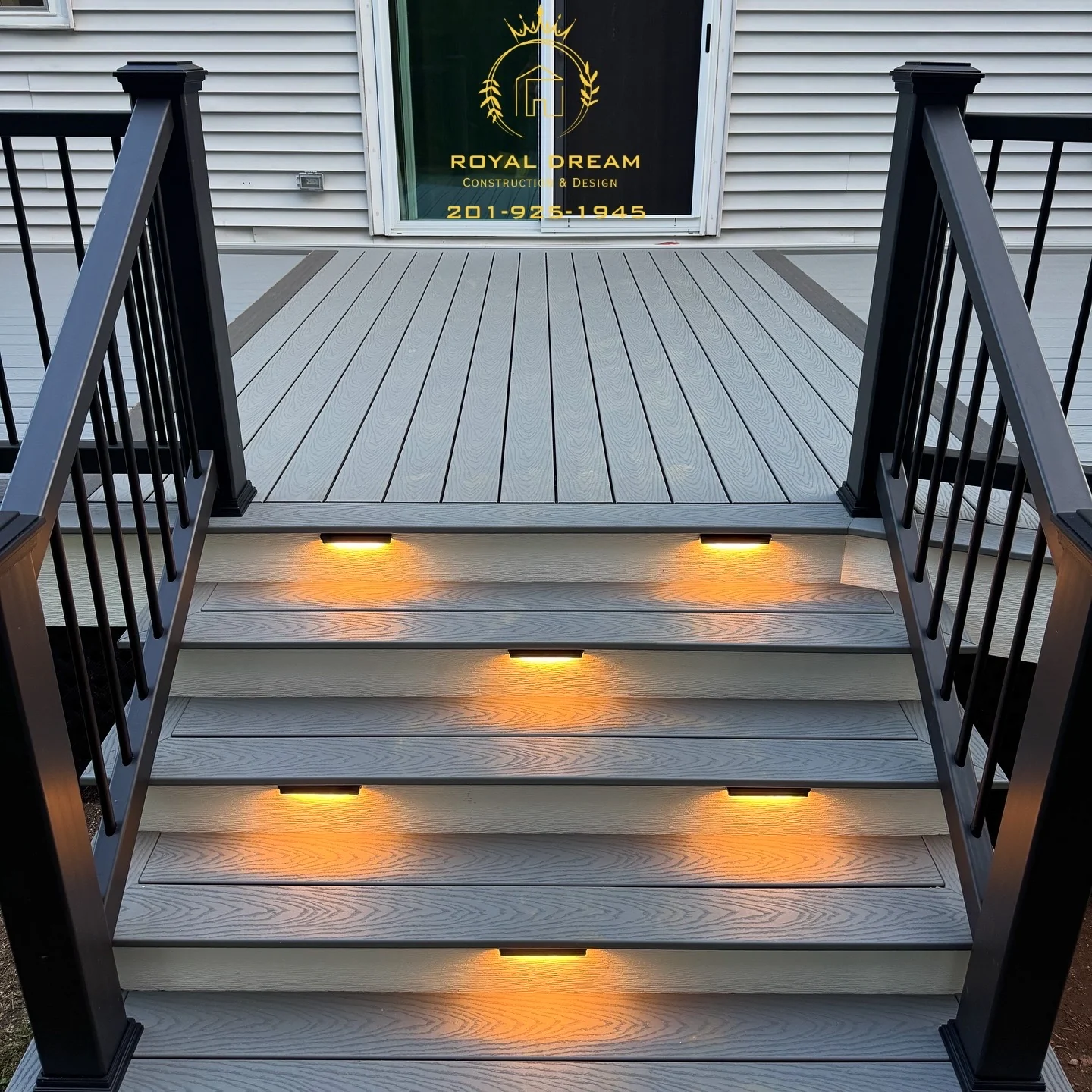 Integrated stair lights highlight the grey boards and contrasting white risers.