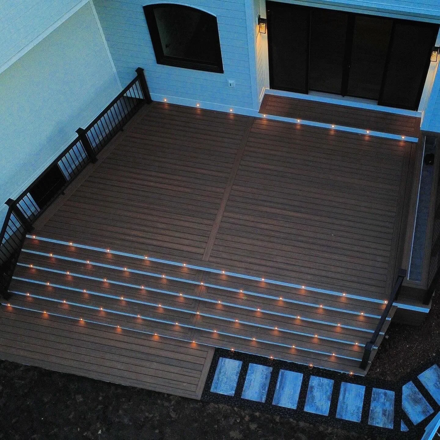 An elevated view of the deck layout, stairs, privacy screen and lighting.