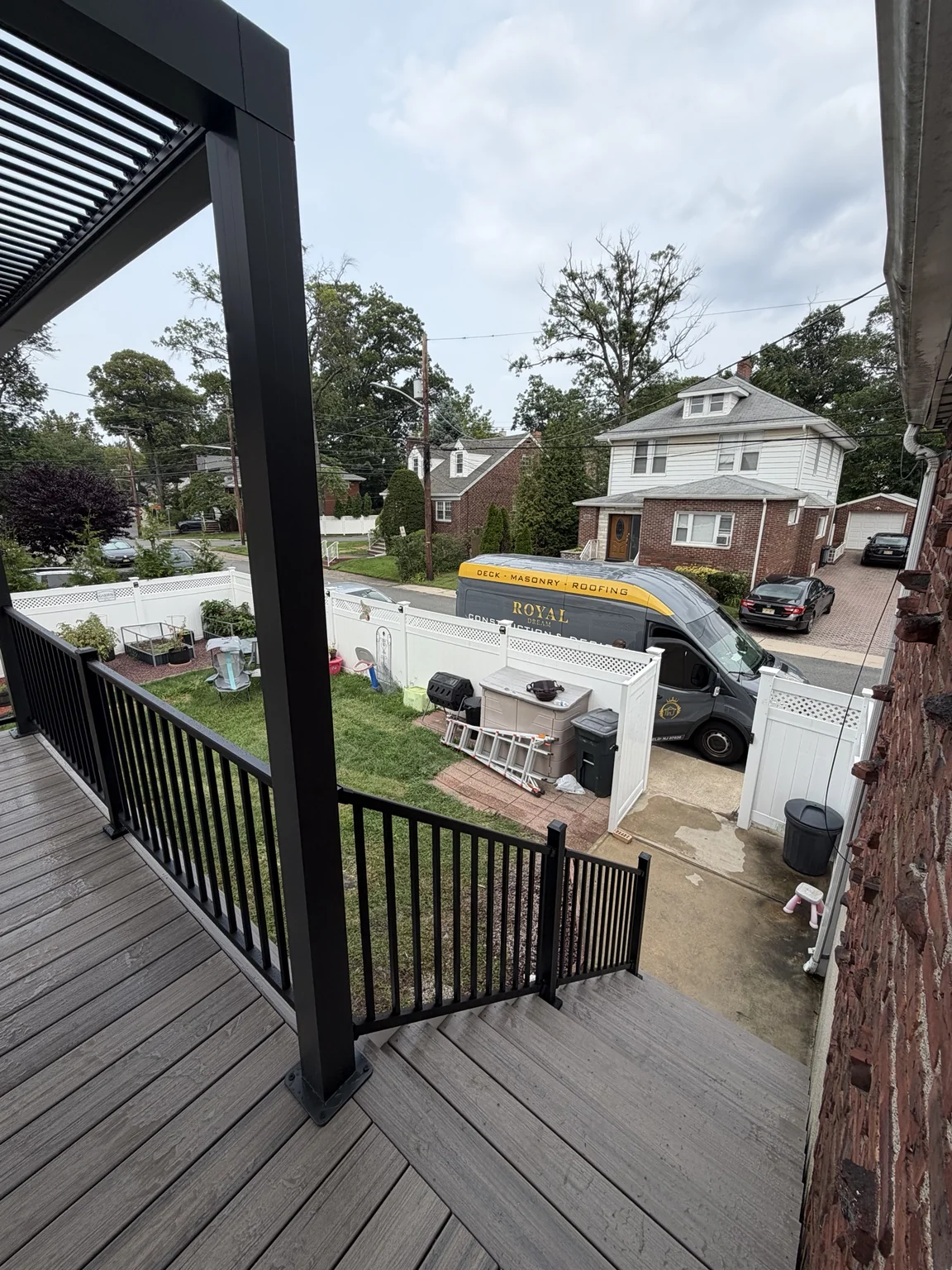 A view from the pergola-covered deck toward the staircase and backyard below.