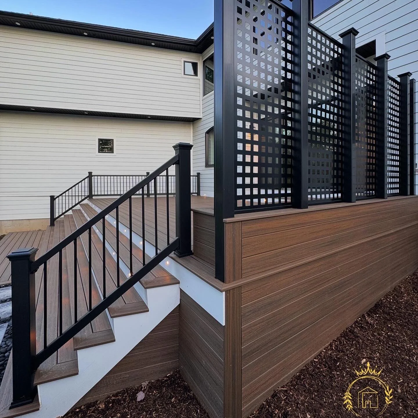 A dark lattice privacy screen, horizontal deck skirting and coordinated railings.