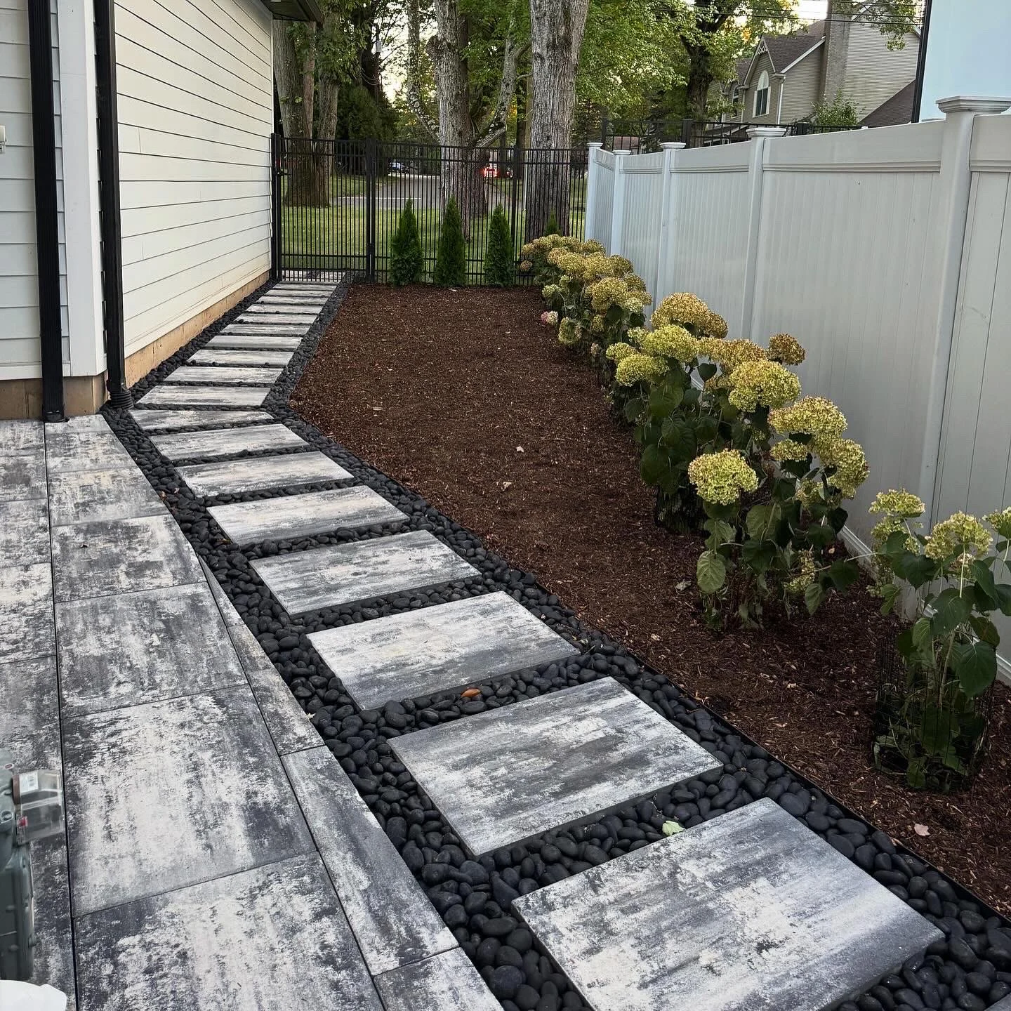 A stepping-stone walkway, gravel borders and planting beds connect the home and yard.