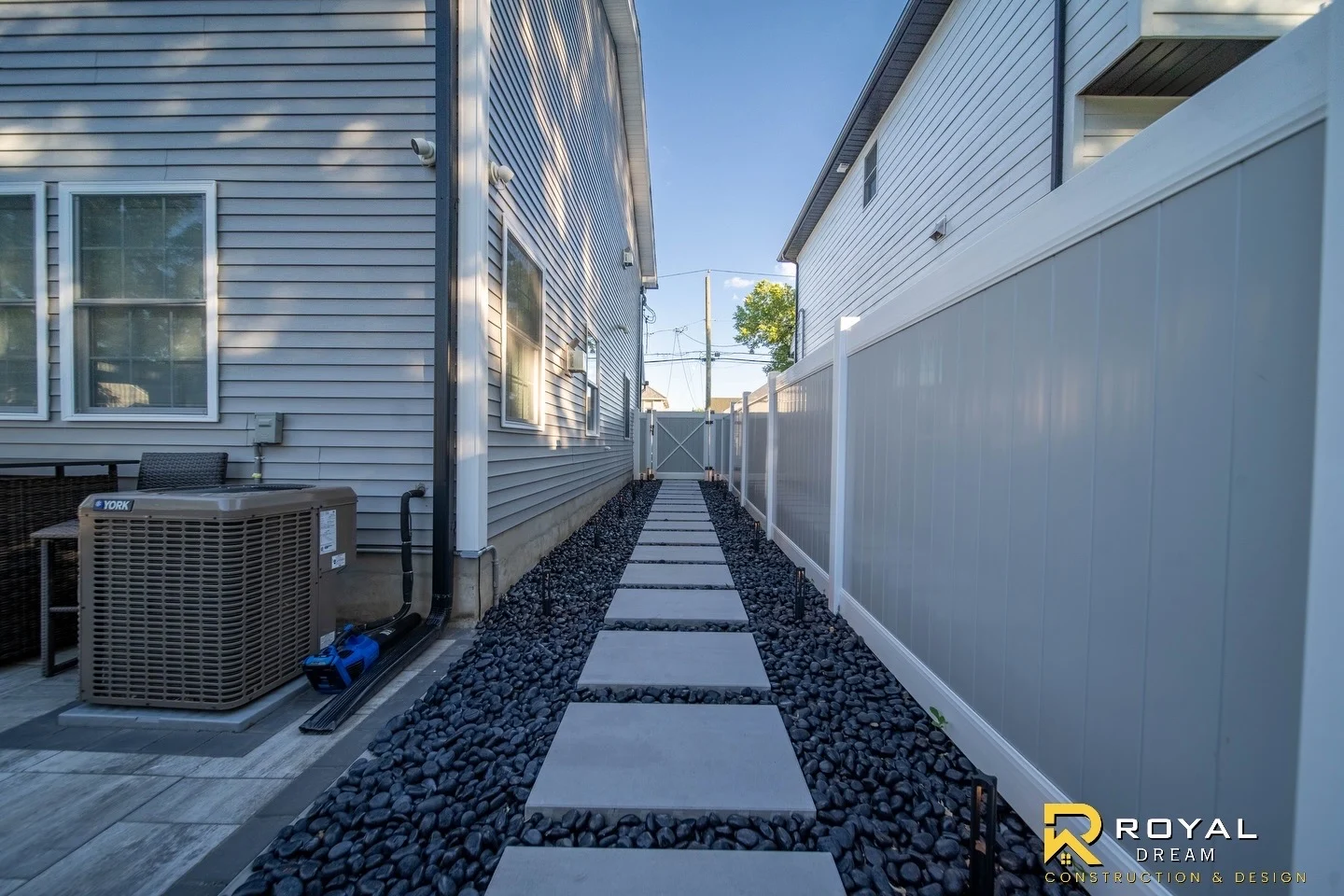 Large stepping stones and dark gravel create a clean side-yard walkway.